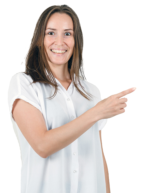 Young lady pointing aside in white blouse and looking pleased. front view. free space for your text